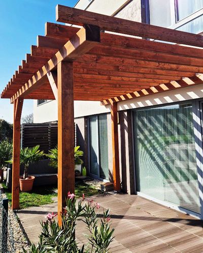 Pergola s tmavo morenou drevenou konštrukciou, celkový pohľad