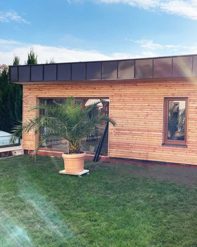 Pergola so svetlo natretou drevenou konštrukciou, iný uhol pohľadu